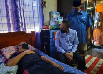 AWANG Hashim (dua dari kiri) ketika melawat Shukor Hassan, 52, bagi menyampaikan bantuan peralatan pemulihan dan sumbangan kotak prihatin orang berinsurans Perkeso di Teluk Bahang, Balik Pulau, Pulau Pinang.