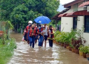 ANGGOTA bomba daripada BBP Ayer Keroh membantu menyelamatkan mangsa banjir kilat di Kampung Sungai Putat, Batu Berendam, Melaka. - UTUSAN/DIYANATUL ATIQAH ZAKARYA