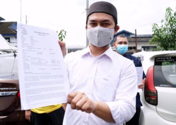 MOHD. Hafez Sabri menunjukkan laporan polis terhadap Lim Kit Siang di pekarangan IPD Ipoh hari ini. - UTUSAN/ZULFACHRI ZULKIFLI.