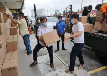 GOOI Hsiao Leung (kiri) membantu kerja-kerja pengagihan kotak makanan yang disumbangkan oleh One Hope Charity and Welfare Berhad kepada penduduk Taman Nagasari, Bukit Mertajam, Pulau Pinang yang dikenakan PKPD bermula Ahad lalu.