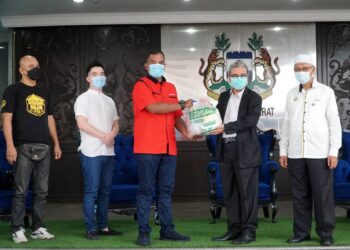 RUMAIZI Baharin (dua dari kanan) menyampaikan sumbangan kepada wakil peniaga Gerbang Malam di Ipoh hari ini. - UTUSAN/ZULFACHRI ZULKIFLI