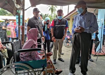 MAHATHIR Mohamad (kanan)  bertanya khabar kepada Sepora Amin yang menerima suntikan vaksin dos kedua pada Program Outreach Imunisasi Covid-19 di Dewan Lembaga Kemajuan Wilayah Kedah (KEDA), Pulau Tuba, Langkawi hari ini. - UTUSAN/NUR AMALINA AZMAN