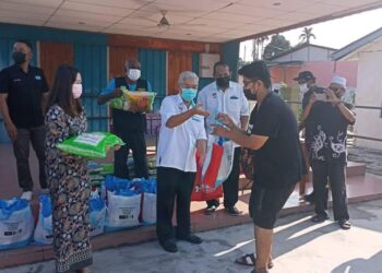 HASSAN Abdul Karim (tengah) dan Ahli Dewan Undangan Negeri (ADUN) Johor Jaya, Liow Cai Tung (kiri) menyampaikan bakul makanan kepada penerima di Kampung Seri Bahagia, Plentong, Pasir Gudang, Johor.