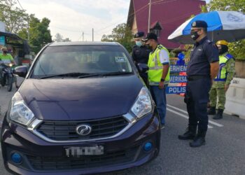 BAHARUDIN Abdullah (tengah) membuat pemeriksaan di sekatan jalan raya di mukim Sura, di Dungun, semalam.
-UTUSAN/NIK NUR IZZATUL HAZWANI NIK ADNAN