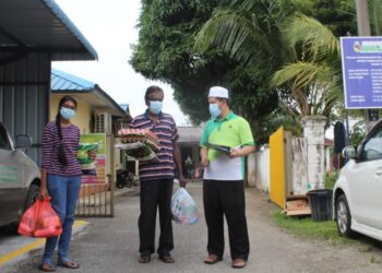 IMAM 1, Masjid Al-Azim, Dr. Mohd Kamel Mat Salleh menyerahkan sumbangan makanan keperluan harian kepada dua orang penerima di masjid berkenaan di Taman Semarak, Nilai hari ini.-UTUSAN/NOR AINNA HAMZAH.