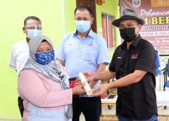RONALD Kiandee (kanan) menyampaikan sijil penyertaan kepada salah seorang belia yang menyertai tanaman cili bara dan halia organik di PPK Beluran, Sabah hari ini