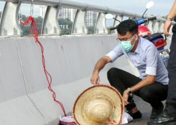 SEPASUKAN anggota polis menurunkan patung bertulisan kerajaan pembunuh yang digantung di sebuah jambatan di Jalan Tun Abdul Razak - Ayer Keroh kira-kira pukul 9 pagi tadi. - UTUSAN/RASUL AZLI SAMAD