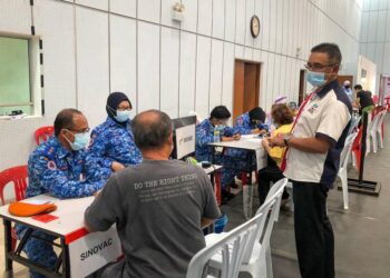 ADLY Zahari (kanan) meninjau perjalanan vaksinasi di Pusat Pemberian  Vaksin (PPV) Dewan Tun Ali, Bukit Katil, Melaka, baru-baru ini. - UTUSAN/MUHAMMAD SHAHIZAM TAZALI