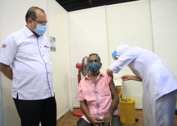 AHMAD Amzad Hashim melihat seorang penerima suntikan vaksin ketika melawat PPV di Stadium Sultan Abdul Halim, Alor Setar. - UTUSAN/MOHD. RAFIE AZIMI
