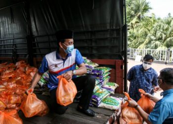MOHD. ZawawI Ahmad Mughni menyerahkan pek keperluan asas kepada warga sekitar Taman Sri Andalas di Taman Rakyat, Klang Selangor. -  UTUSAN/ZULFADHLI ZAKI