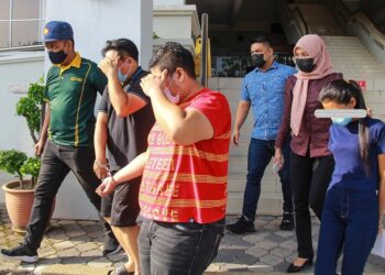 DUA lelaki dan seorang wanita yang dituduh atas kesalahan menolong menyembunyikan wang berjumlah RM270,000 milik seorang juruteknik di bawa keluar oleh anggota polis selepas didakwa di Mahkamah Majistret Seremban. - UTUSAN/MUHAMMAD IZZAT TERMIZIE