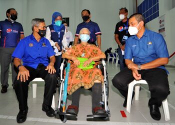 MOHD. Rashid Hasnon (kiri) beramah mesra dengan seorang warga emas, Sophie Ng (tengah) sambil diperhatikan oleh Dr. Sahrudin Jamal ketika hadir pada Program Jelajah Vaksin Bergerak Prihatin Johor di Dewan Serbaguna Sri Stulang di Johor. - UTUSAN/RAJA JAAFAR ALI
