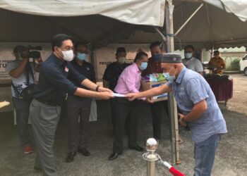 ZULKIFLE Ab. Rahman menyampaikan sumbangan kepada salah seorang penerima Program Bantuan Prihatin Maik di Muzium Islam Negeri di sini, Kota Bharu. - UTUSAN/ROSLIZA MOHAMED