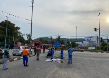 WANITA maut setelah basikal ditunggangnya bergesel dengan sebuah treler di Slim River hari ini.  - UTUSAN/IHSAN PDRM