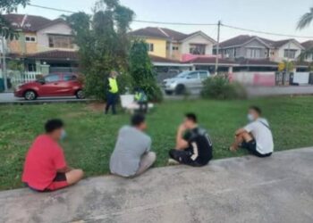EMPAT lelaki yang dikompaun kerana bermain bola keranjang di Taman Venice, Lumut  semalam. - UTUSAN/IHSAN PDRM