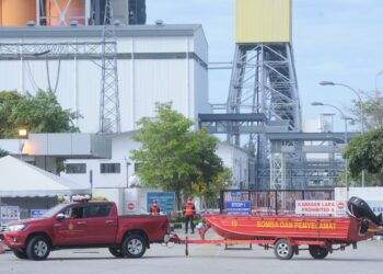 PASUKAN bomba bersama aset memasuki JEV di Chuah, Port Dickson bagi menjalankan operasi mencari dan menyelamat seorang lelaki yang terjatuh ke dalam laut bersama lori dipandunya awal pagi tadi.-UTUSAN/MOHD. SHAHJEHAN MAAMIN