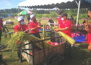 AHMAD Ridzwan Yahya (dua dari kiri) bersama ahli persatuan sedang menyusun barang makanan dan daun ketupat untuk diagihkan kepada golongan memerlukan di Kampung Perepat, Kapar, Klang. - UTUSAN/ABDUL RAZAK IDRIS