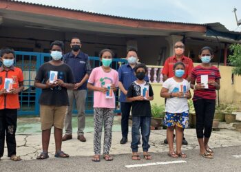TAN Lek Khang (belakang dua dari kanan) bergambar bersama antara pelajar B40 yang menerima telefon pintar untuk digunakan bagi PdPR di Chaah, Segamat, Johor.