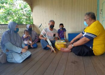 MOHD. Kamal Ariffin (tengah) menerima bakul makanan sumbangan warga Sekolah Kebangsaan (SK) Duyung di rumahnya di Kampung Duyung Kecil, Kuala Terengganu. - UTUSAN/TENGKU DANISH BAHRI TENGKU YUSOFF