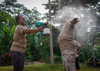 PETUGAS sembelihan korban disanitasi terlebih dahulu bagi mengelak berlaku penularan Covid-19 di Bukit Antarabangsa. - UTUSAN/SHIDDIEQIIN ZON
