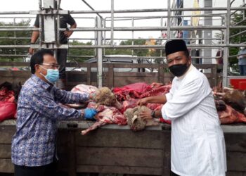 OSMAN Sapian (kiri) menyerahkan daging korban kepada wakil masjid untuk diagihkan kepada penerima di Pusat Khidmat DUN Kempas, Johor Bahru. - FOTO/KHAIRUL MOHD. ALI