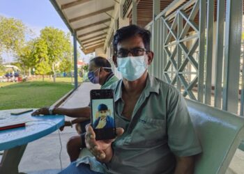 M. Kumar menunjukkan gambar anaknya, K. Viknesh yang meninggal dunia di Hospital Port Dickson selepas dilaporkan rebah ketika bertugas di Klinik Kesihatan Bukit Pelandok, Port Dickson semalam. - UTUSAN/NOR AINNA HAMZAH