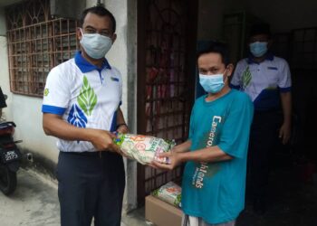 SAIPOLYAZAN (kiri) memberikan sumbangan beras kepada seorang asnaf, Hashim Isa (dua dari kanan) di Flat Taman Alam Megah, Shah Alam, Selangor hari ini - UTUSAN / MOHAMAD NAUFAL MOHAMAD IDRIS