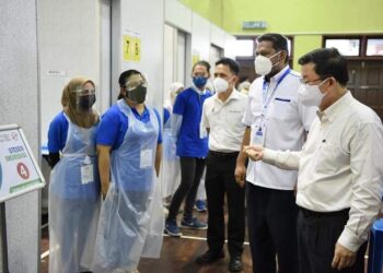 CHOW Kon Yeow ketika meninjau operasi salah sebuah PPV di Pulau Pinang yang kini mencecah 30,000 dos suntikan sehari.