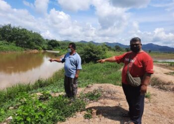 MAZLI Isa (kanan) dan Abd. Malik Mat Ali menunjuk parit yang menjadi sumber bekalan air untuk kegunaan pesawah di Padang Nyior, Padang Terap, Kedah. -  UTUSAN/MOHD. RIFAAT ABD. HAMID