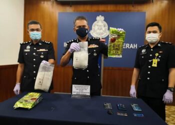 MOHD ZAIDI Abdullah (tengah) menunjukkan dadah yang dibungkus dalam plastik Chinese tea yang dirampas dalam serbuan di Kota Kinabalu, semalam