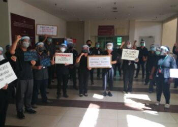 Doktor-doktor kontrak berkumpul sambil memegang placard menuntut diberi jawatan doktor tetap di kawasan Hospital Shah Alam hari ini.- UTUSAN/ ABDUL RAZAK IDRIS
