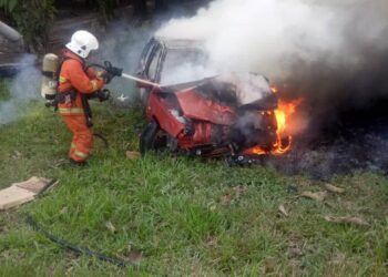 ANGGOTA bomba memadam kebakaran kereta Proton Iswara yang terbabas di Jalan Kampung Colombia, Ayer Tawar dekat Lumut. - UTUSAN/IHSAN JBPM