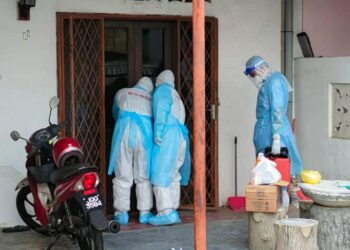 PIHAK bomba membuka pintu kediaman mangsa bagi memeriksa keadaan seorang lelaki yang ditemukan tidak sedarkan diri sepanjang menjalani kuarantin kendiri di Kampung Kenangan Tun Syed Nasir, Tangkak, Johor.