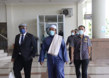 MOHD. Idrus, Ahmad @ Ab. Kadir (tengah) diiringi peguam Saiful Izham Ramli (kiri) dan pegawai SPRM di Kompleks Mahkamah Alor Setar hari ini.