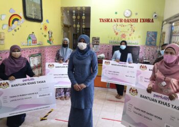 RINA Mohd. Harun bergambar bersama penerima Bantuan Khas Taska ketika program PEMULIH di Bandar Baru Salak Tinggi hari ini. - UTUSAN/NUR SHARIEZA ISMAIL