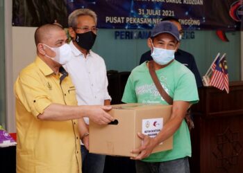 SAARANI Mohamad (kiri) menyampaikan kotak makanan kepada nelayan darat di Lenggong hari ini. - UTUSAN/ZULFACHRI ZULKIFLI