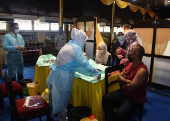 PETUGAS kesihatan melakukan suntikan vaksin kepada penerima di Istana Balai Besar, Kota Bharu. - UTUSAN/ROSLIZA MOHAMED