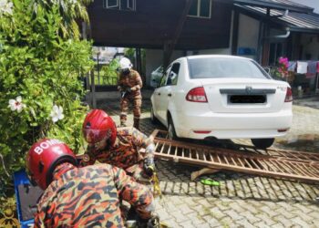 PASUKAN bomba menyelamatkan mangsa yang masih berada di bawah pagar yang dirempuh sebuah kenderaan di Taman Luyang, Kota Kinabalu. - IHSAN JBPM SABAH