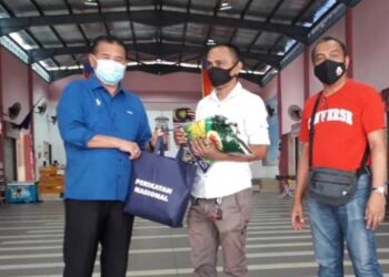 CHE Zakaria Mohd. Salleh (kiri) menyerahkan bakul makanan kepada ahli Persatuan Anak-anak Perantau Johor di Pasar Muafakat Sabah, Bandar Seri Alam, Pasir Gudang, Johor.