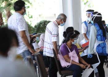 SUKARELAWAN membantu orang ramai yang hadir secara walk-in di PPV Movenpick ketika tinjauan hari pertama inisiatif itu hari ini. - UTUSAN/FAIZ ALIF AHMAD ZUBIR