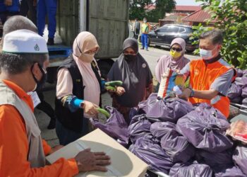 SAID Sidup (kanan) ketika penyampaian bantuan Bakul Makanan Prihatin Negara di kawasan PKPD Kampung Berlian di Tumpat. - UTUSAN/ROSALWANI CHE SOH
