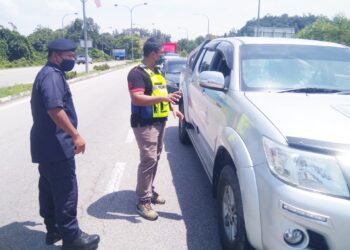 BAHARUDIN Abdullah (kiri) ketika meninjau sekatan jalan raya (SJR) di Che Lijah di Dungun. - UTUSAN/NIK NUR IZZATUL HAZWANI NIK ADNAN