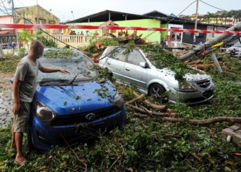 SEBATANG pokok besar yang tumbang dipanah petir lalu menghempap lima buah kenderaan di pekan Ulu Tiram, Johor Bahru di Johor. - UTUSAN/RAJA JAAFAR ALI