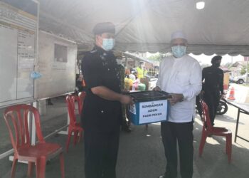 AHMAD Yakob menyampaikan sumbangan bakul makanan kepada pasukan keselamatan yang bertugas di PKPD Kampung Kebakat, Wakaf Bharu, Tumpat, Kelantan. - UTUSAN/YATIMIN ABDULLAH