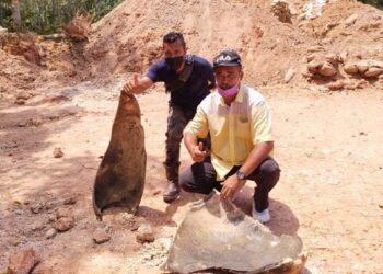 PENDUDUK melihat serpihan bom era Perang Dunia Kedua seberat 226 kilogram yang diletupkan di lokasi asal ditemukan di Felda Triang 1 di Bera, Pahang. - UTUSAN/SALEHUDIN MAT RASAD