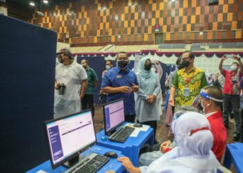 MUHAMMAD Sanusi Md. Nor bertanyakan sesuatu kepada petugas di PPV Outreach IPT di UUM. - UTUSAN/SHAHIR NOORDIN