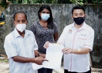 M. KULASEGARAN (kiri) menunjuk teks tawaran yang diterimanya melalui aplikasi WhatsApp milik Setiausaha Sulitnya selepas membuat laporan polis di IPD Ipoh. - UTUSAN/ZULFACHRI ZULKIFLI