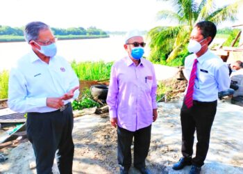 MUSTAPA (kiri) melihat kerja-kerja membaik pulih tebing Sungai Kelantan di Kampung Pohon Celagi, Pasir Mas, Kelantan hari ini. - UTUSAN/YATIMIN ABDULLAH