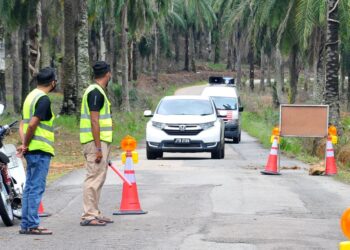 PENDUDUK Kampung Sungai Melayu mengawal laluan masuk ke kampung mereka berikutan terdapat penduduk yang positif Covid-19 di Gelang Patah, Iskandar Puteri di Johor. -UTUSAN/RAJA JAAFAR ALI