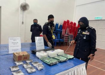 SURINA SAAD (kanan) menunjukkan dadah jenis methamphetamine dan ganja yang dirampas dalam beberapa serbuan di sekitar negeri ini dan Selangor dalam sidang akhbar di Ibu Pejabat Polis Kontinjen (IPK) Perlis hari ini.- UTUSAN/NAZLINA NADZARI